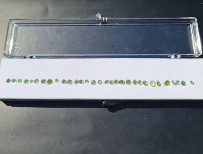 לוט 31 אבני פרידוט מלוטשות, 10 קראט, מגיעות בקופסת תצוגה עם תג מחיר של 500$ והכיתוב 