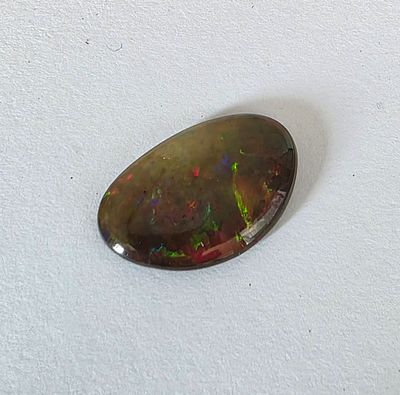 אבן אופל מלוטשת, משקל 10.46 קראט, יפהפיה, נוצצת וזוהרת בשלל צבעים, הוצאה מבריפקה עם 