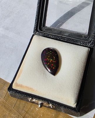 אבן אופל שחור אוסטרלי מלוטשת, נדירה, משקל 5.4 קראט, מדהימה ביופיה, נוצצת בשלל צבעים 