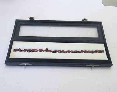 לוט 26 אבני גרנט רודלייט מלוטשות, משקל 27 קראט, מגיעות בקופסת תצוגה עם תג מחיר של 