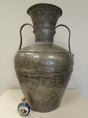 Старинный металлический сосуд с объемным корпусом и двумя фигурными ручками, а также 