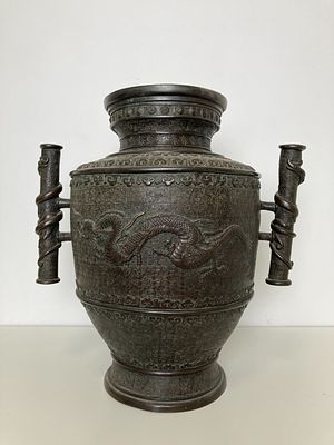 Старинная бронзовая ваза с традиционным изображением дракона и графически украшенным фоном. Две 