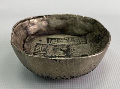 Круглый китайский денежный слиток (ингот) из серебросодержащего сплава с надписями и клеймами. 