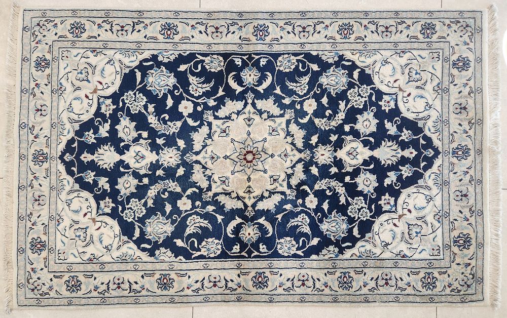 שטיח נעין פרסי קלאסי, 
דוגמת מדליון מרכזי ופרחים על רקע כחול ולבן. 
157x100 ס"מ.