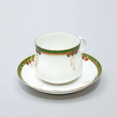 Кофейная пара с росписью золотом и зеленой отводкой. Россия, Рига, фабрика М.С. Кузнецова 