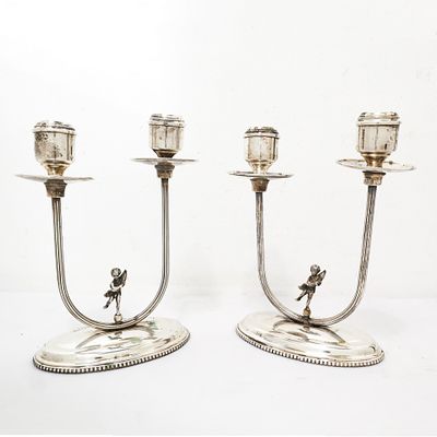 Coppia di candelabri a due fiamme in argento 800 con puttino sulla base gr. 545