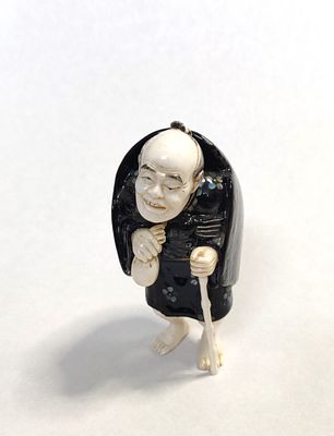 יפן. פסלון יפני מחומר גרמי יפיפה. דמות כפופה נשענת על מקל. הבעה יחודית בפניה. מלאכת מחשבת של 