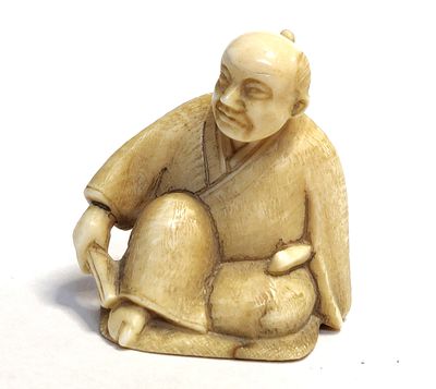 יפן. פסלון נצקה יפני ישן נושן עד עתיק. דמות בגלימה מסורתית ישובה ואוחזת דבר מה בידיה. פנים רבות 