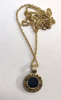 שרשרת ותליון שעליו הלוגו של המותג היוקרתי "בולגארי" BULGARI כיתוב בלעז. הכל בצבע זהב. אורך 