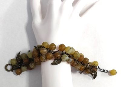 צמיד מרשים ליד. עשוי מכדורי חומר דמוי ג'ייד, בגוונים פסטליים. בצירוף עלי מתכת זעירים. בעל 