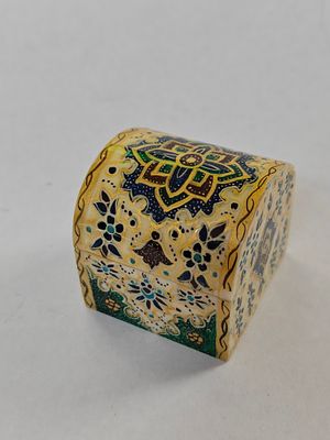 תיבה זעירה יפיפייה. עשויה מעצם, מעוטרת מאוד. יחודה בכך שעם הרמת המכסה העגול, מתגלה מכסה פנימי 