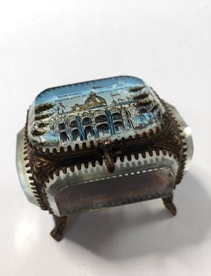 תיבה קטנה עתיקה, עשויה זכוכית איכותית. עם מסגרת מתכת פליז אף היא, מקושטת ביד אמן. התיבה ניצבת 