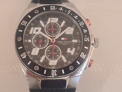 שעון יד מאסיבי TOMMY HILFIGER "טומי הילפיגר". חתום. בזל עם ספרות. לוח שחור. ספרות זורחות בלבן. 