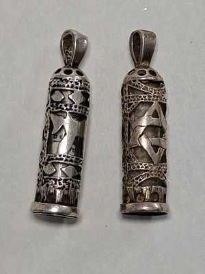 שני תליוני קמע מכסף. עם הנייר בפנים. יפים מאוד. באחד חסרה תחתית. אורך: 3.5 ס"מ. משקל שניהם: 