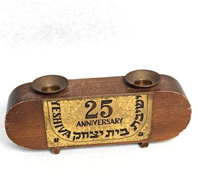 צמד פמוטי פליז לשבת על בסיס עץ. פריט ישן ביותר של ישיבת "בית יצחק" עם פלאק מתכת שניתן לישיבה 
