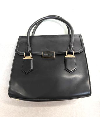 תיק לאישה חתום CHARLES &amp; KEITH על הסוגר המרכזי המתכתי. גם בבסיס הידיות וגם על תג בתוך התיק. 