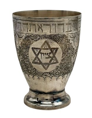 כוס קידוש פרסית עשויה כסף 84, מעוטרת בחריטות של מגן דוד, מנורה וגפנים ועם הכיתוב "ברוך אתה ה' 
