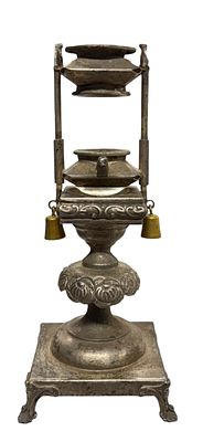 פמוט עתיק מצופה כסף להבדלה, עם בסיס לנר שניתן להגבהה.מעוטר בתבליטי בעלי חיים ופעמונים בצדדים. 