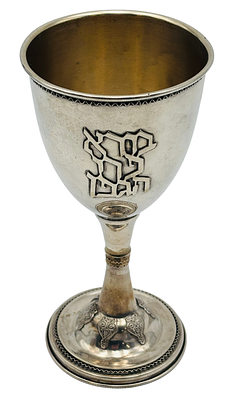 גביע יין גדול ממדים עשוי כסף 925 תוצרת בן ציון, מעוטר בתבליטי גפנים והכיתוב "בורא פרי הגפן". 