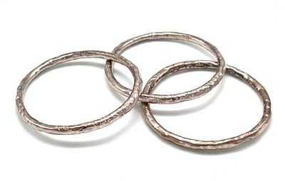 Lotto di tre bracciali rigidi in argento 925 martellato. - Lotto di tre bracciali rigidi in 