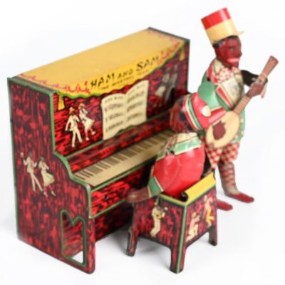 Strauss "Ham & Sam" Minstrel Band Circa 1920. This lithographed tin toy depicts a banjo and 