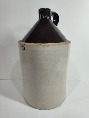 5 Gallon Crock Jug. One schip to spout. 20 inches tall x 11 inch diameter