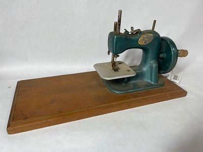 Stitch Mistress Childs Sewing Machine. Gears and needle turn smoothly. On wooden base. 15.5x7x7