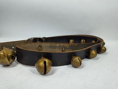 Double graduated strand of brass sleigh bells. 15 bells on leather belt.