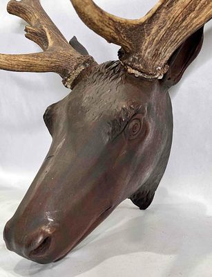 Wooden Stag head with real antlers. Antlers are glued on, one side is slightly loose. 27in wide 