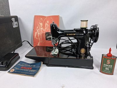 Singer featherweight sewing machine. Sewing machine works and comes with box of attachments 