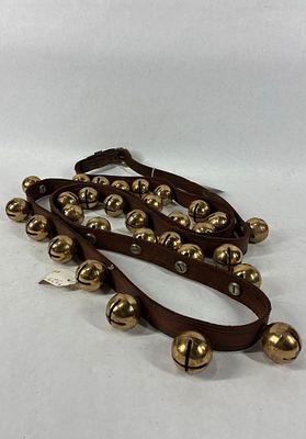 Strand of brass double throated sleigh bells. 30 small brass bells on leather belt.