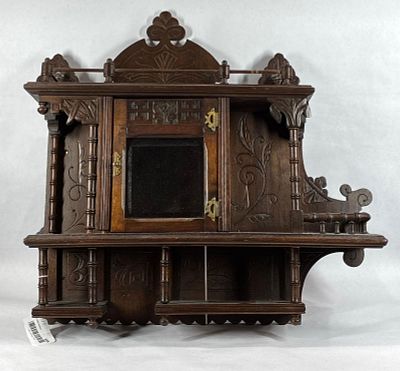 Unusual early carved hanging cabinet. Small petite carved shelf with center storage. Shows a few 