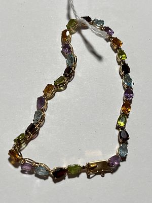 14K Gold & Stones Bracelet. Peridot, Tourmaline, and garnets in alternate colors. 4 inch diameter.