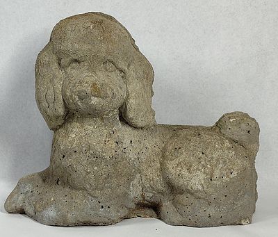 Concrete Reclining Poodle Sculpture. This cast concrete sculpture depicts a poodle in a 