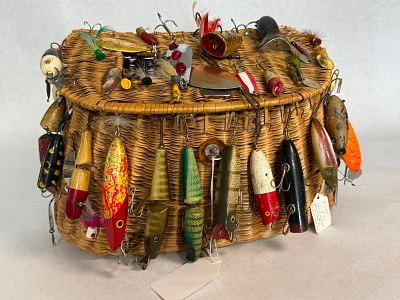 Gibbs & Yakima Lures & Wicker Creel. An assortment of antique and fishing tackle displayed on a 