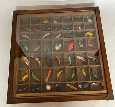 Fishing Lures in Wood Display Case. An assortment of and antique fishing lures presented in a 