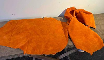 A Pair of Orange Sueded Hog Leather Hides. This lot consists of two loose orange leather pigskin 