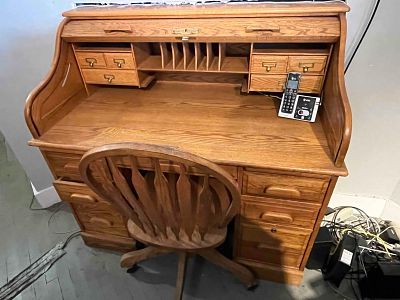 Solid Oak Roll-Top Desk & Swivel Chair. A traditional-style oak roll-top desk accompanied by a 