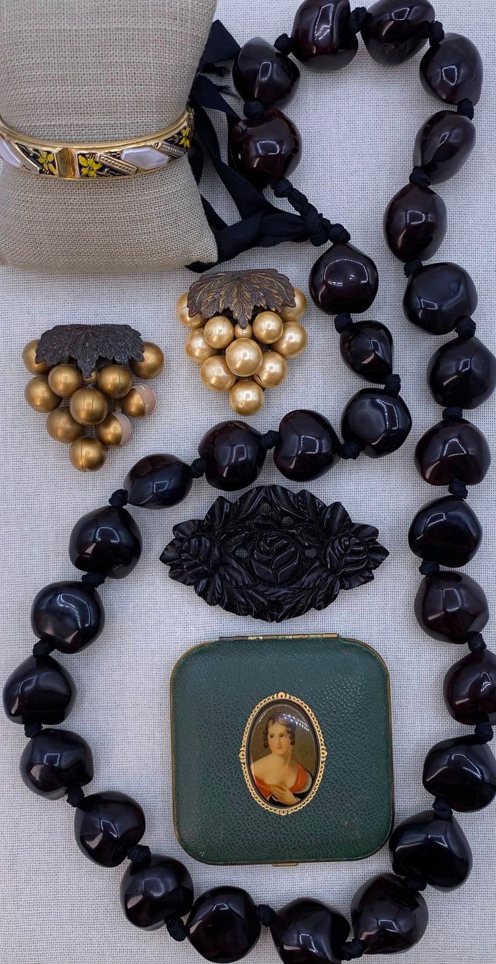 Lot 166: 6 pc Art Deco Bakelite Brooch, Dress Clips, Damascene Style Bangle, Kukui Nut, Mondaine Compact