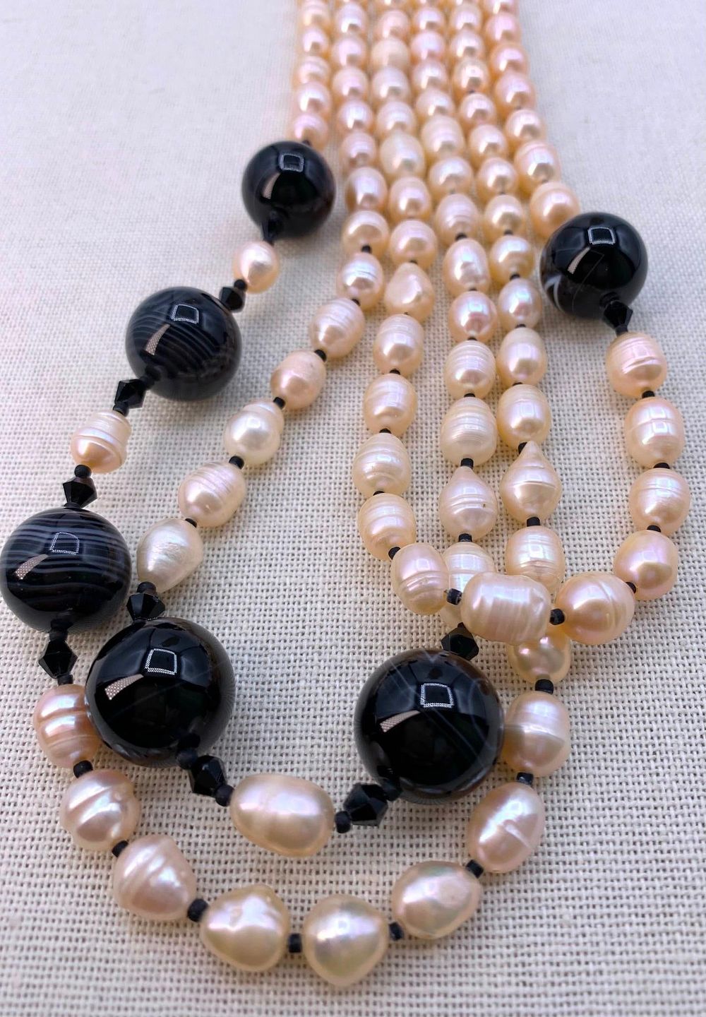 Lot 196: Ringed Apricot Freshwater Pearl, Banded Art Glass and Crystal Asymmetrical Triple Strand Necklace