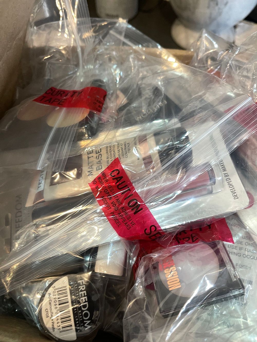 Security-sealed mystery clearance bundle containing branded high-street cosmetics and retail 