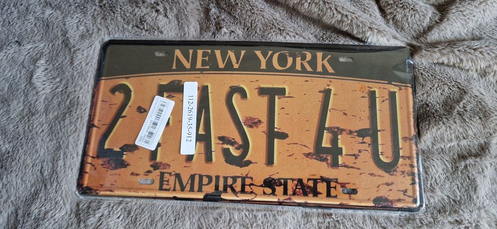 Lot 30: Decorative metal license plate featuring a vintage, rustic design.