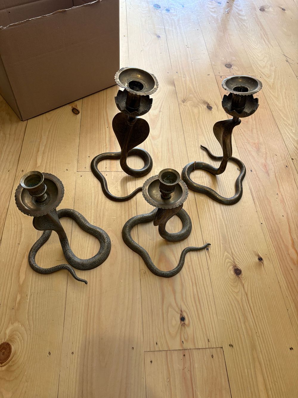 Lot 618: Four brass snake designed candle sticks