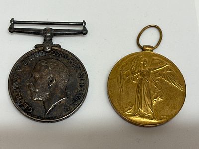 A Pair of WWI British Military Medals. A pair of World War I military medals, one dark 