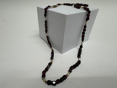 A Tumbled Garnet and Pearl Beaded Necklace with Yellow Metal Clasp. This beaded necklace 