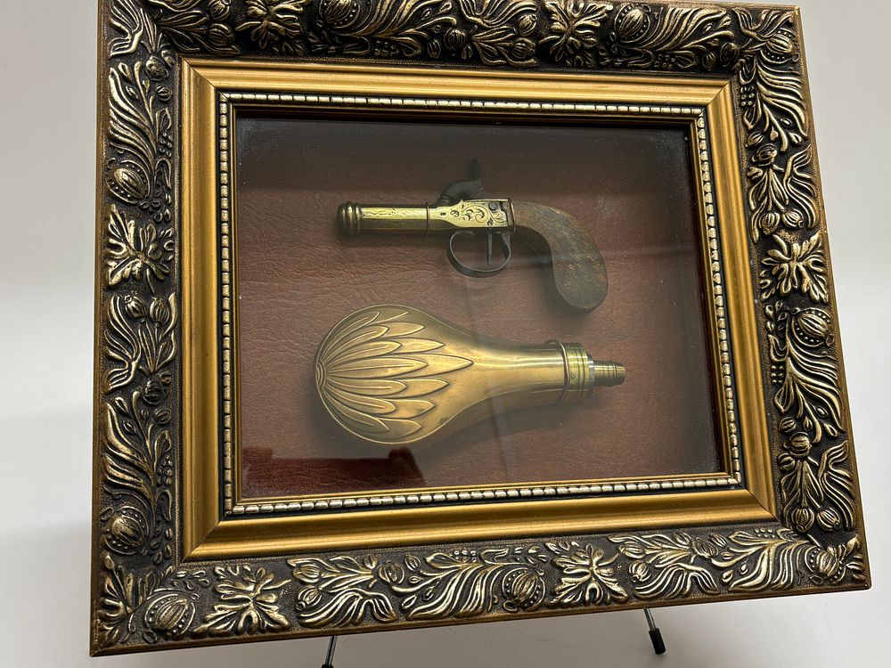 Lot 59: A Framed Pair of Miniature Brass Derringer Pistol and Powder Flask Replicas
