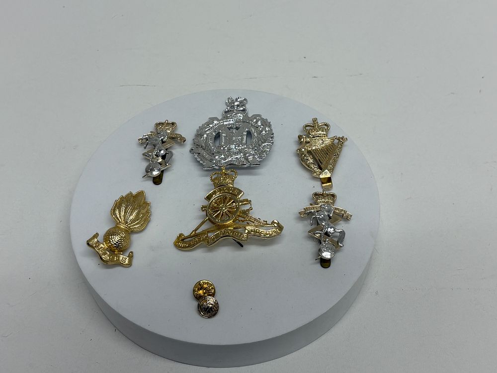 Lot 80: A Collection of Eight British Army Mixed-Metal Military Insignia including Royal Artillery Cap Badges