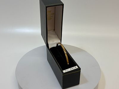 A 9 Carat Gold Hinged Bangle with Screw-Head Motifs London 1984. 3.86g. A 9 carat yellow gold 