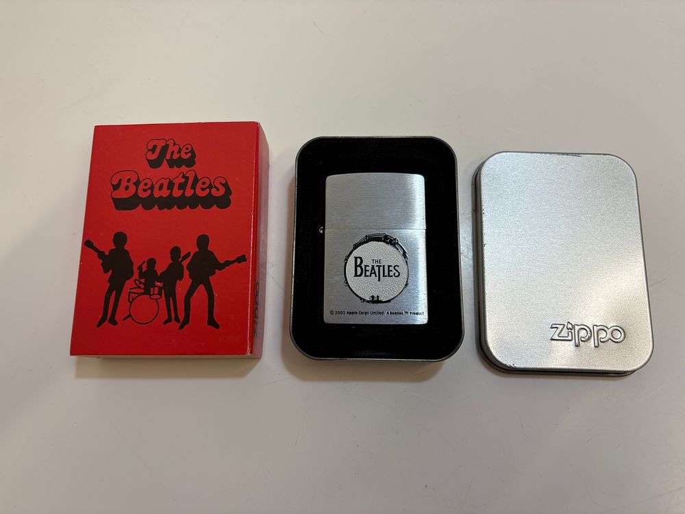 Lot 185: A 2002 The Beatles Zippo Brushed Chrome Lighter with Original Presentation Tin and Packaging
