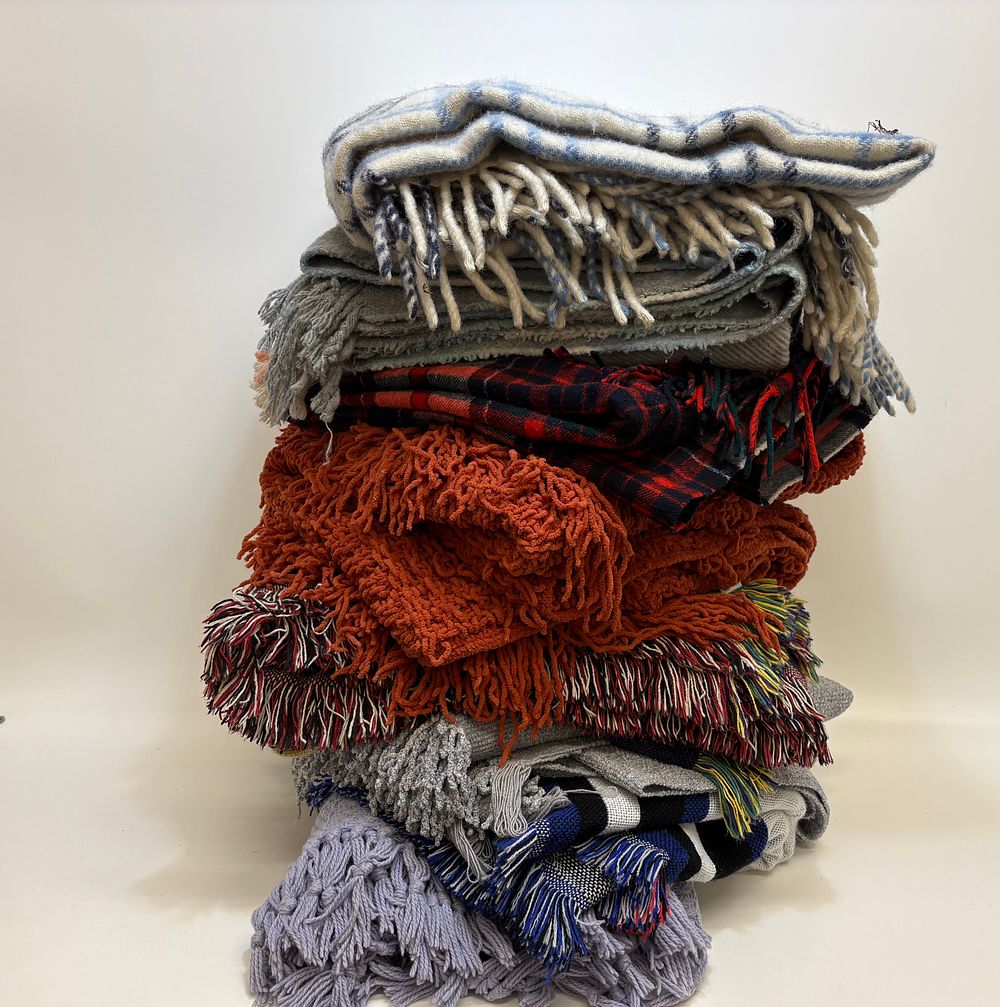 Lot 591: A collection of nine assorted blankets, throws, and travel rugs including a Johnstons of Elgin tartan rug